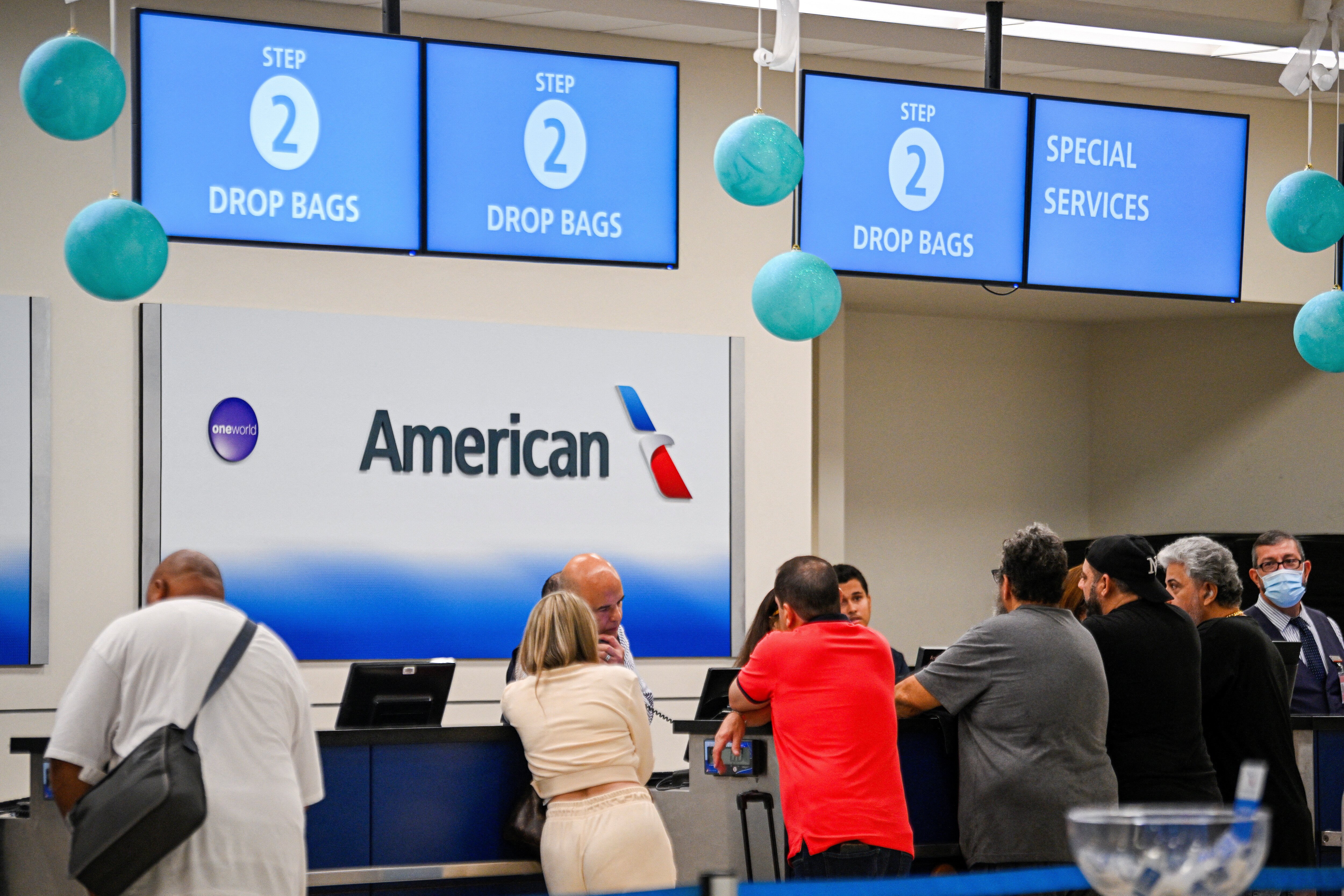 People stand in front of the counter at the Luis Munoz Marin International Airport as American Airlines resumes its flights after a technical glitch forced the carrier to issue an hour-long ground stop, disrupting travel for thousands of people on Christmas Eve, one of the busiest periods of the year, in San Juan, Puerto Rico December 24, 2024. REUTERS/Miguel Rodriguez