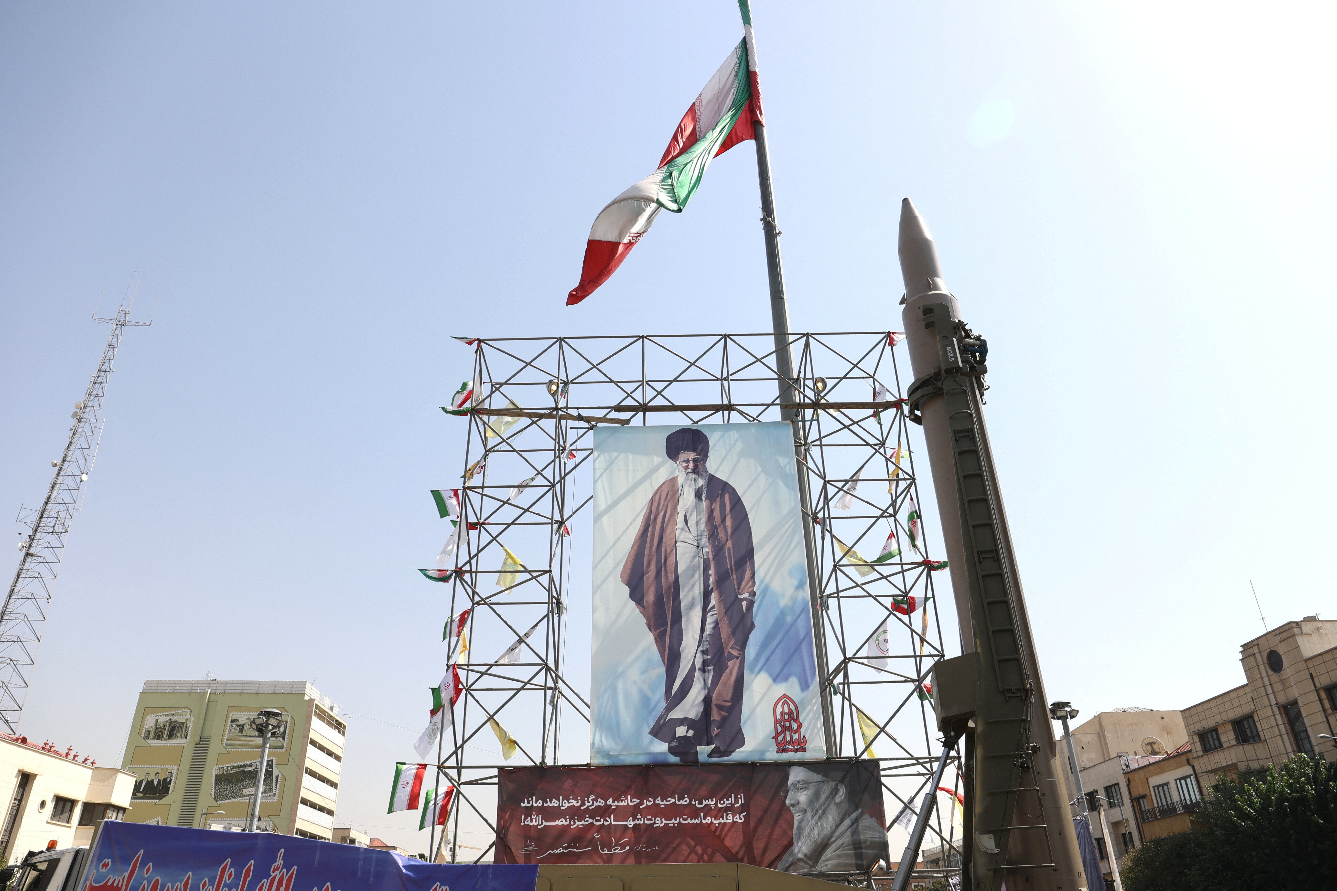 An Iranian missile system is displayed next to a banner with a picture of Iran's Supreme Leader Ayatollah Ali Khamenei and the late Lebanon's Hezbollah leader Hassan Nasrallah, in a street in Tehran, Iran, October 2, 2024. Majid Asgaripour/WANA (West Asia News Agency) via REUTERS