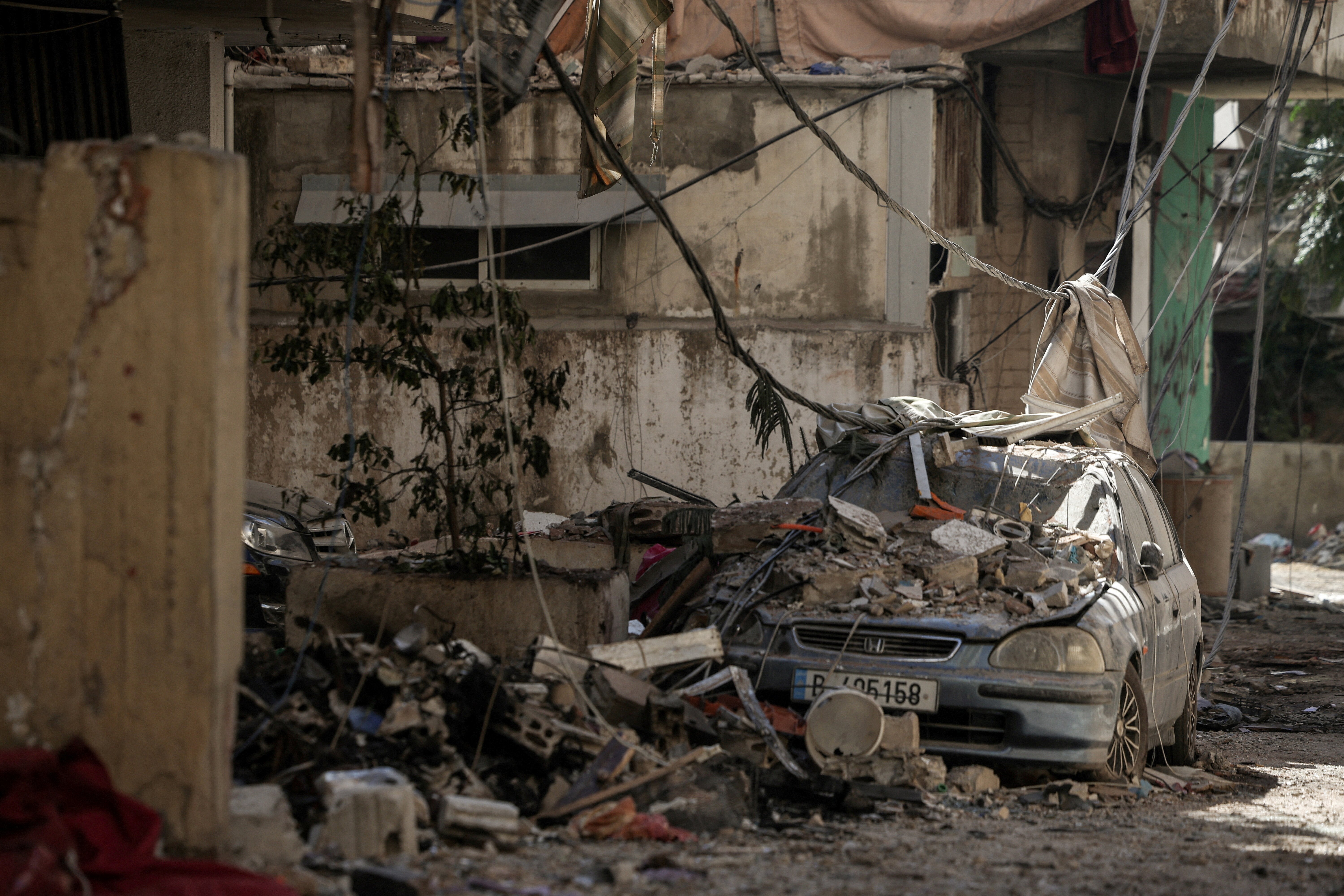 A damaged vehicle lies amidst the rubble in the aftermath of the Israeli strikes, amid ongoing hostilities between Hezbollah and Israeli forces, in the Chiyah area of Dahiyeh, Beirut, Lebanon, October 5, 2024. REUTERS/Louisa Gouliamaki