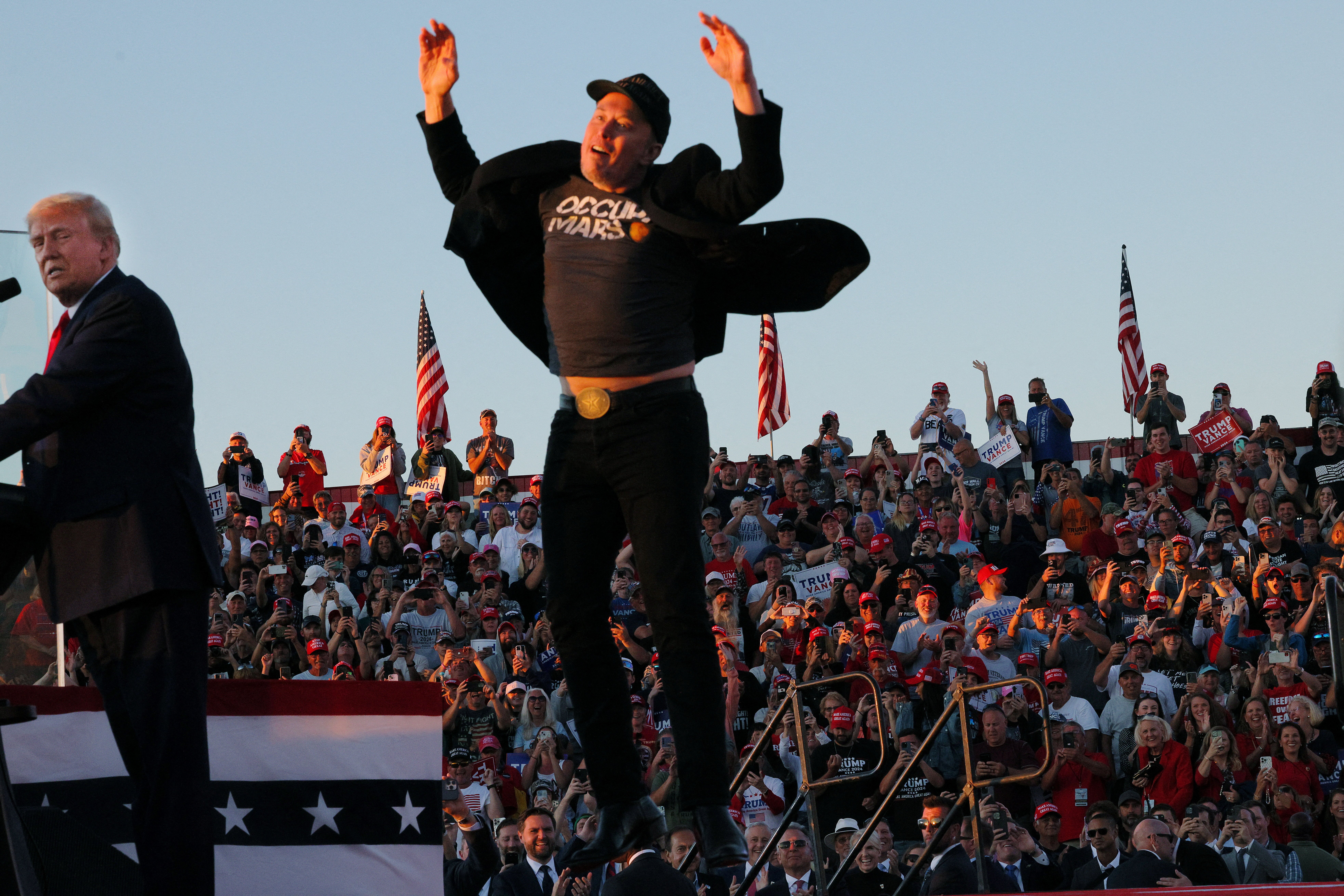 Tesla CEO and X owner Elon Musk reacts next to Republican presidential nominee and former U.S. president Donald Trump during a campaign rally, at the site of the July assassination attempt against Trump, in Butler, Pennsylvania, U.S., October 5, 2024. REUTERS/Brian Snyder