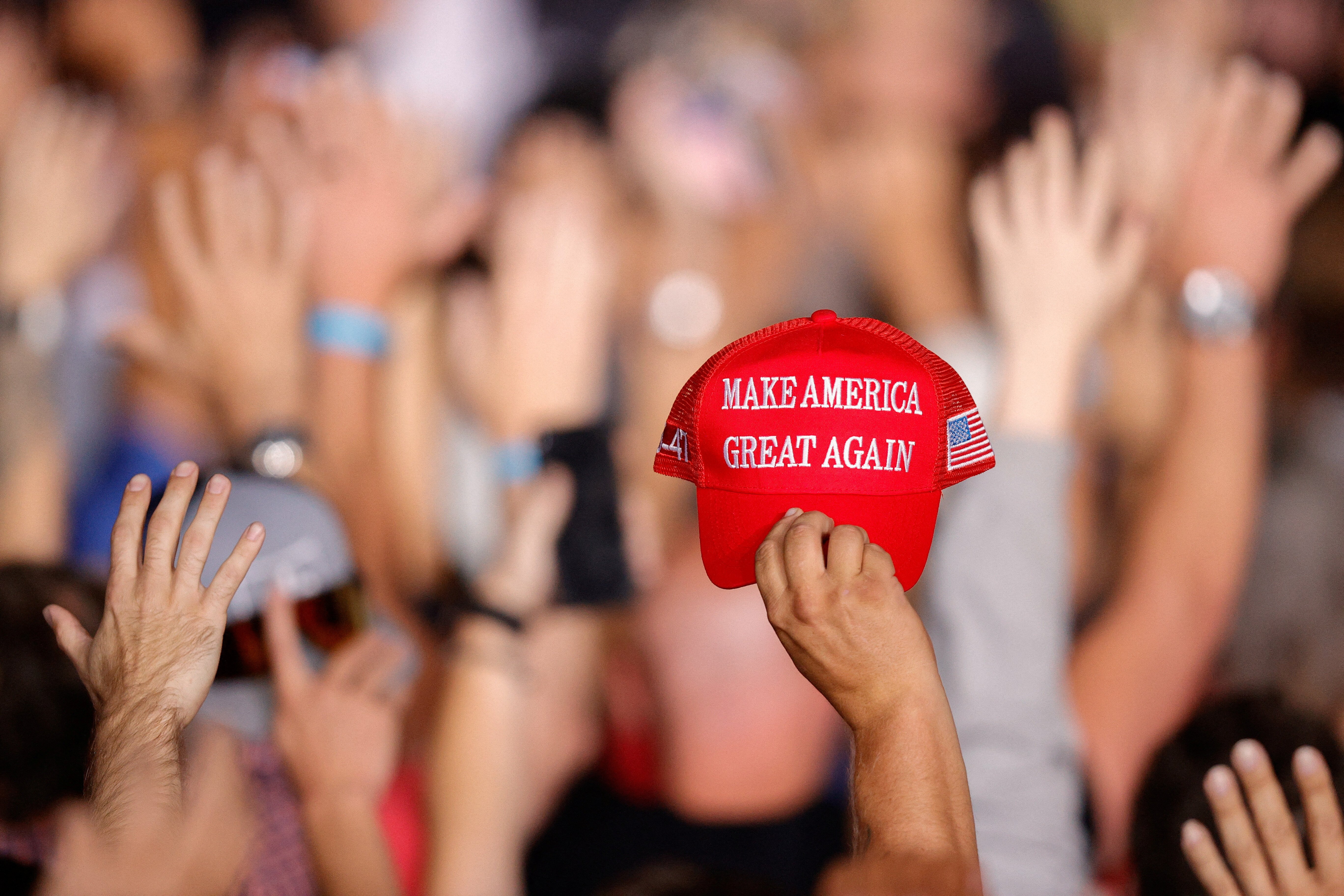 A supporter of Republican presidential nominee and former U.S. President Donald Trump holds a MAGA hat during a rally at Gaylord Rockies Resort and Convention Center in Aurora, Colorado, U.S., October 11, 2024. REUTERS/Isaiah J. Downing