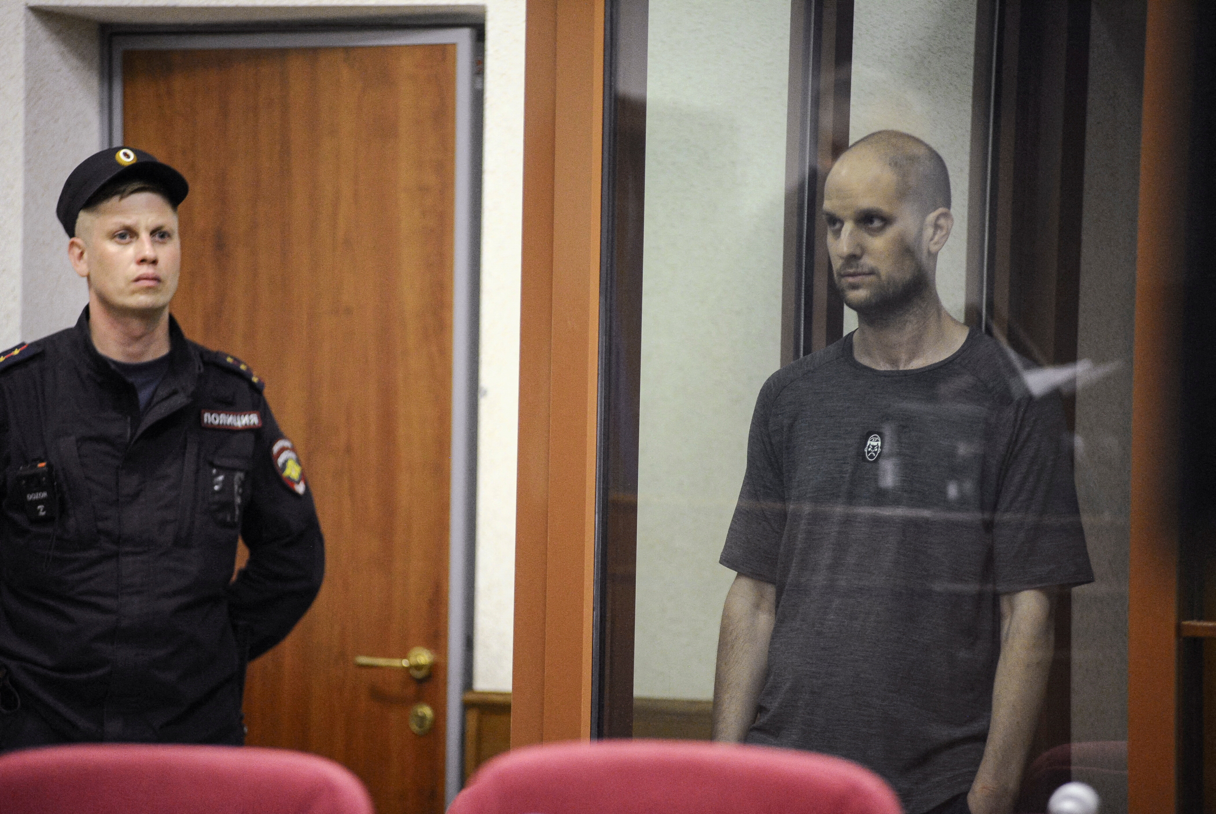 Wall Street Journal reporter Evan Gershkovich, who faces charges of espionage, stands inside an enclosure for defendants as he attends a court hearing in Yekaterinburg, Russia July 19, 2024. REUTERS/Dmitry Chasovitin