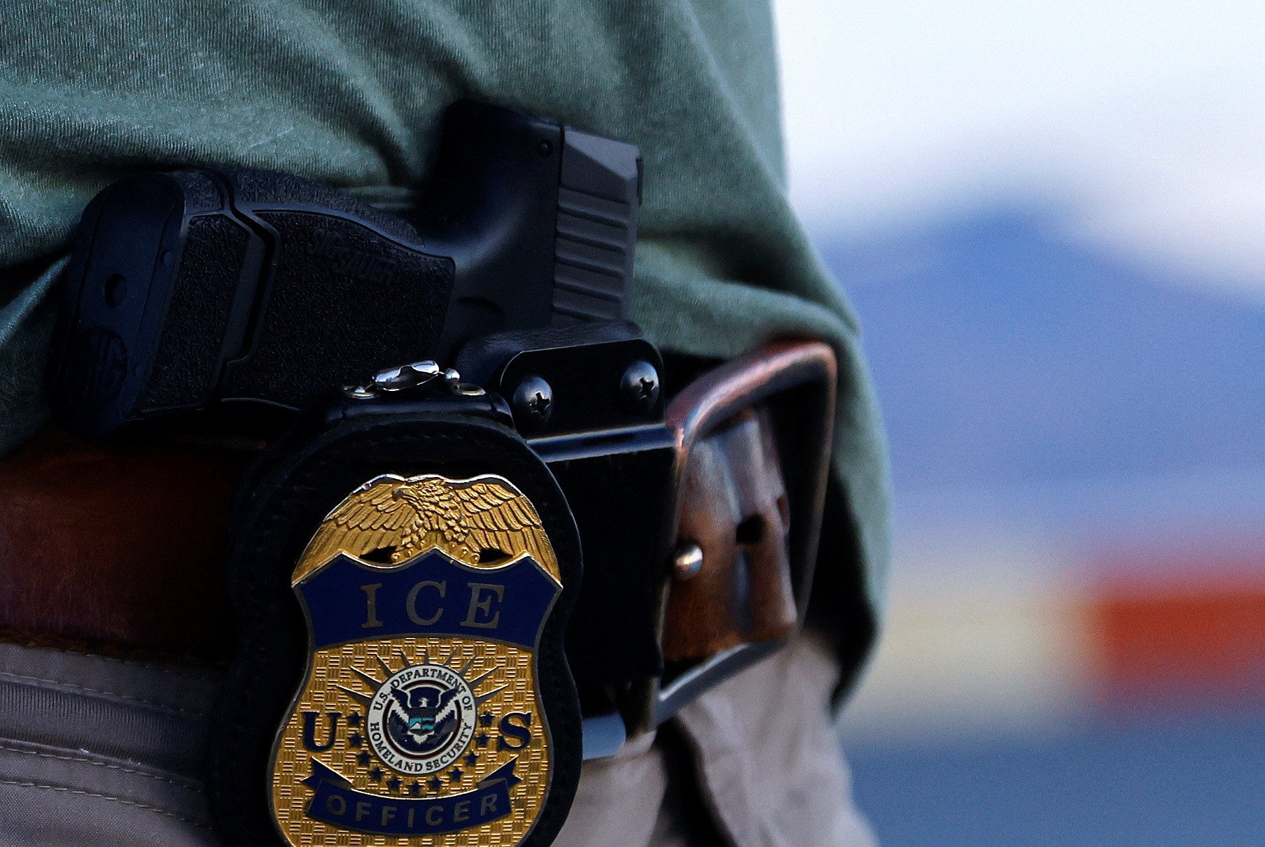 The badge of a U.S. Immigration and Customs Enforcement (ICE) agent is seen during an operation with migrants being transferred to a plane to be expelled under U.S. Title 42 from the United States to their country by U.S. Immigration and Customs Enforcement (ICE) agents and Border Patrol agents, at the airport in El Paso, Texas, U.S., May 10, 2023. REUTERS/Jose Luis Gonzalez