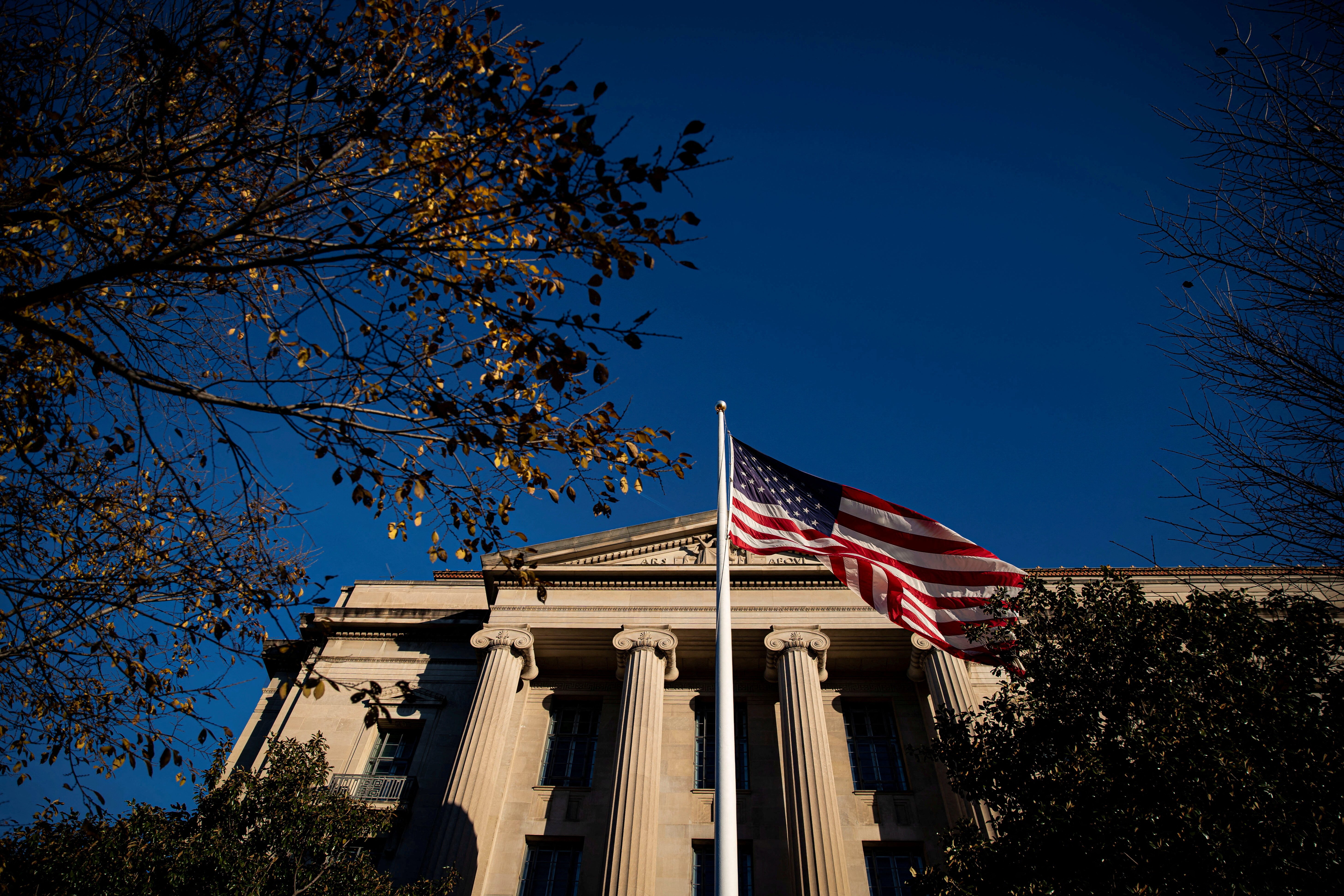 An American flag waves outside the U.S. Department of Justice Building in Washington, U.S., December 15, 2020. REUTERS/Al Drago/File Photo