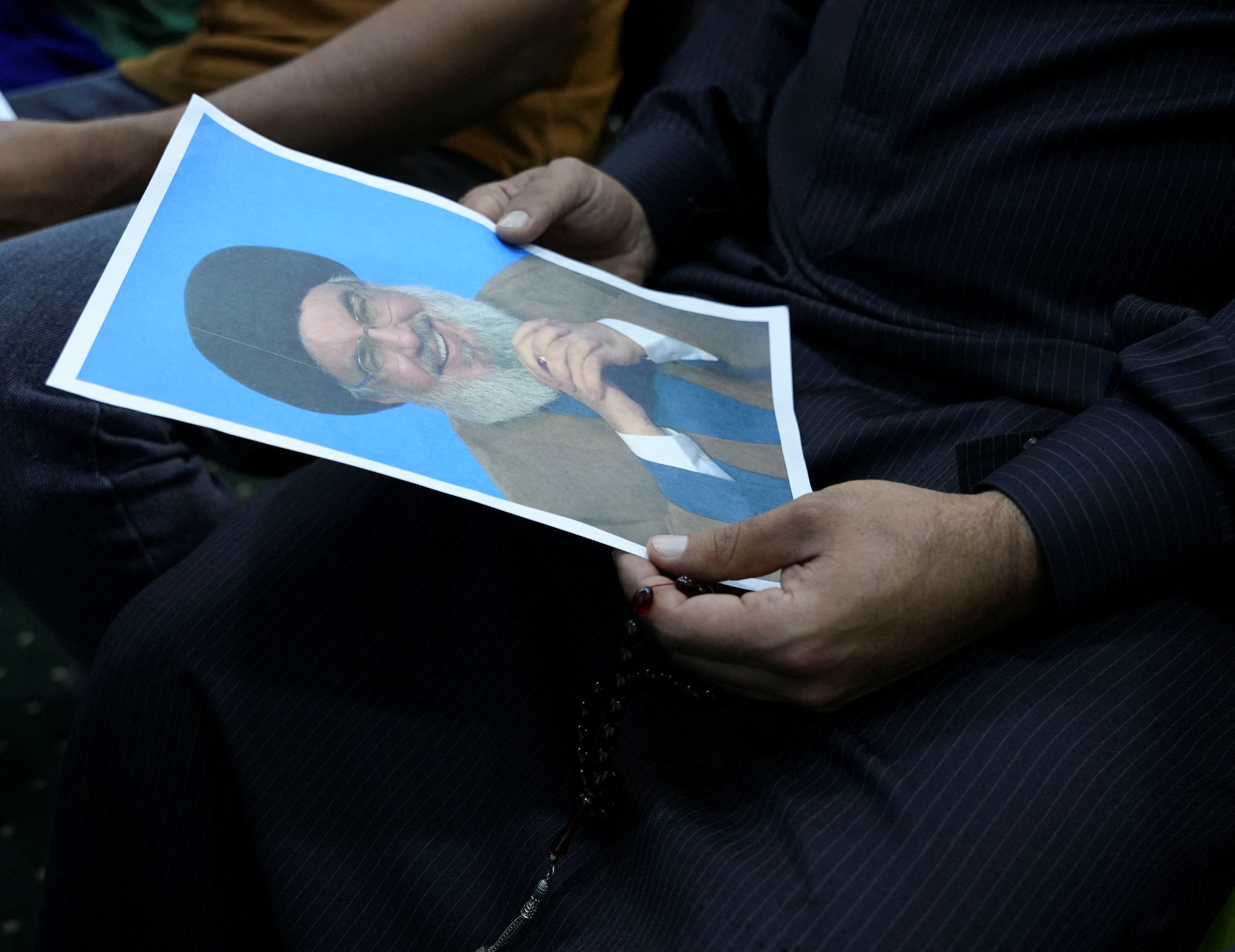 An Iraqi volunteer holds a picture of Lebanon's Hezbollah leader Sayyed Hassan Nasrallah, while registering his name to support Hezbollah, following a call from the Jihad and Construction Movement, a Shi'a Islamist Iraqi political party, in Basra, Iraq, on September 27, 2024. REUTERS/Essam al-Sudani