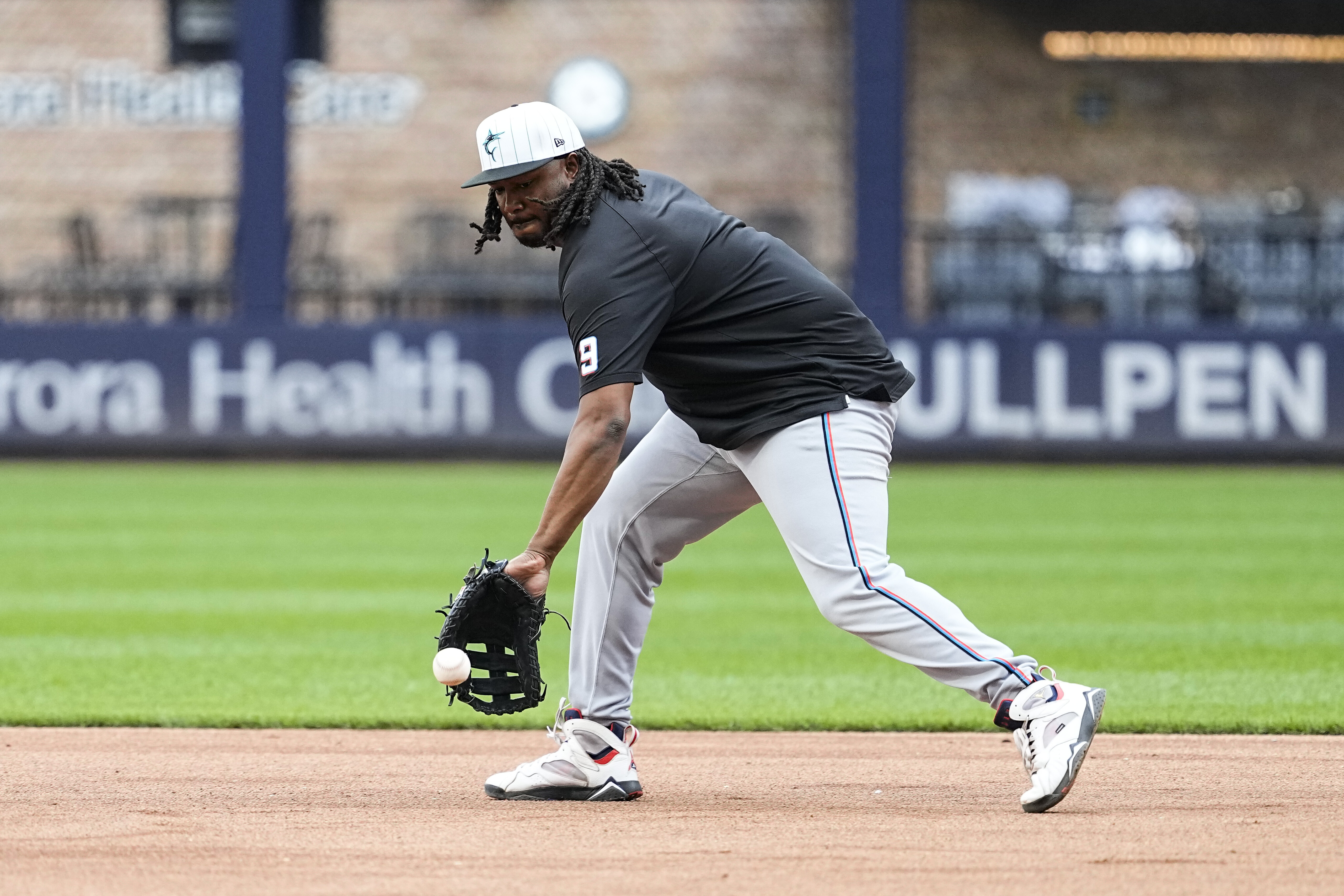 Jul 27, 2024; Milwaukee, Wisconsin, USA; Miami Marlins first baseman Josh Bell (9) fields a ground ball during warmups prior to the game against the Milwaukee Brewers at American Family Field. Mandatory Credit: Jeff Hanisch-USA TODAY Sports