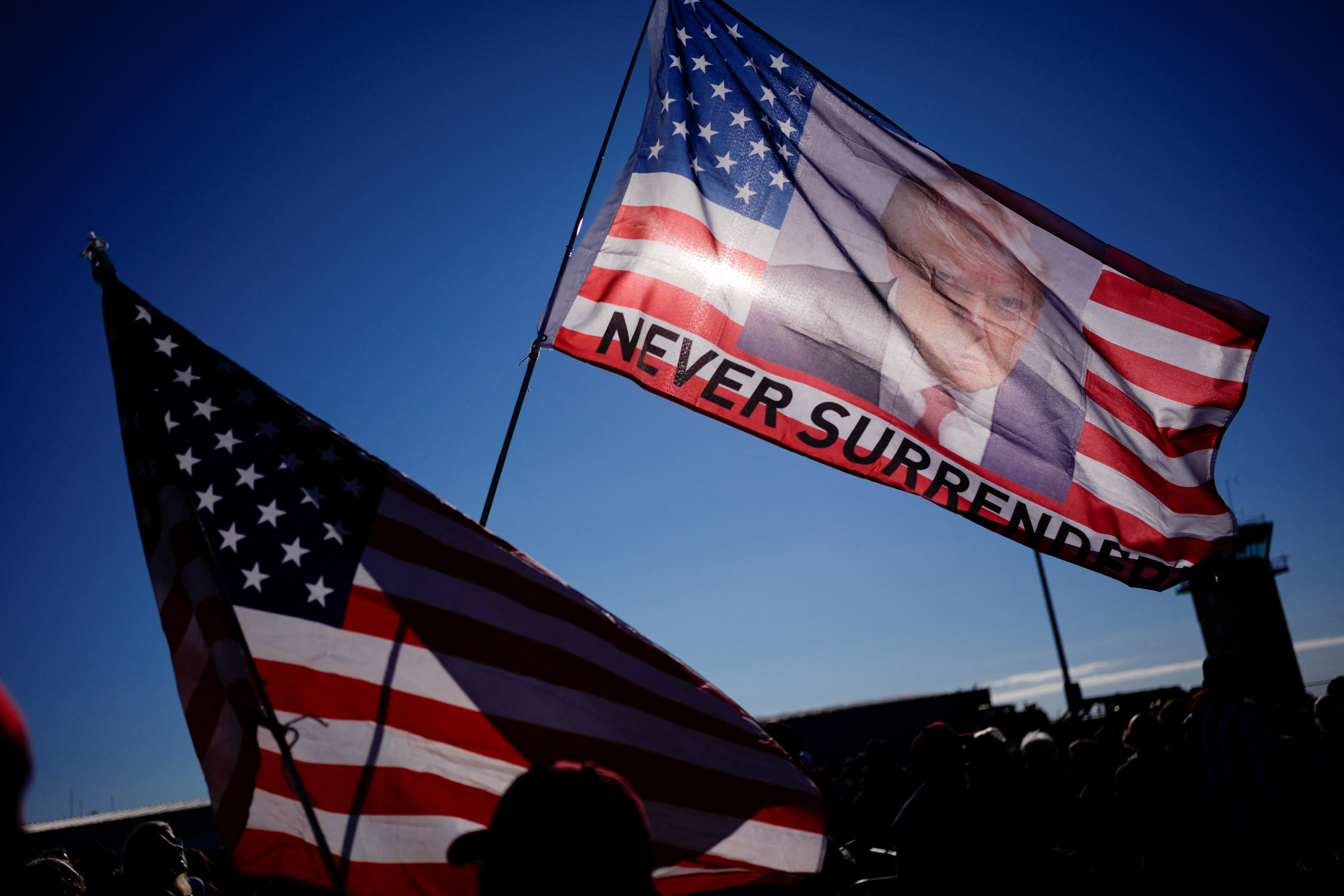 A view shows the U.S. flag with an image of Republican presidential nominee and former U.S. President Donald Trump in Mosinee, Wisconsin, U.S. September 7, 2024. REUTERS/Brian Snyder